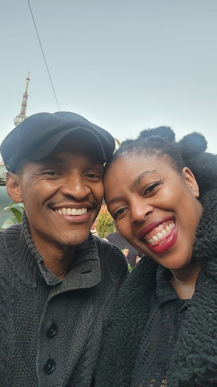 A photograph of a smiling couple in winter jackets
